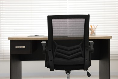 Photo of Black chair, laptop and desk in office