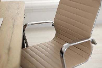 Photo of Beige leather chair and desk in office, closeup