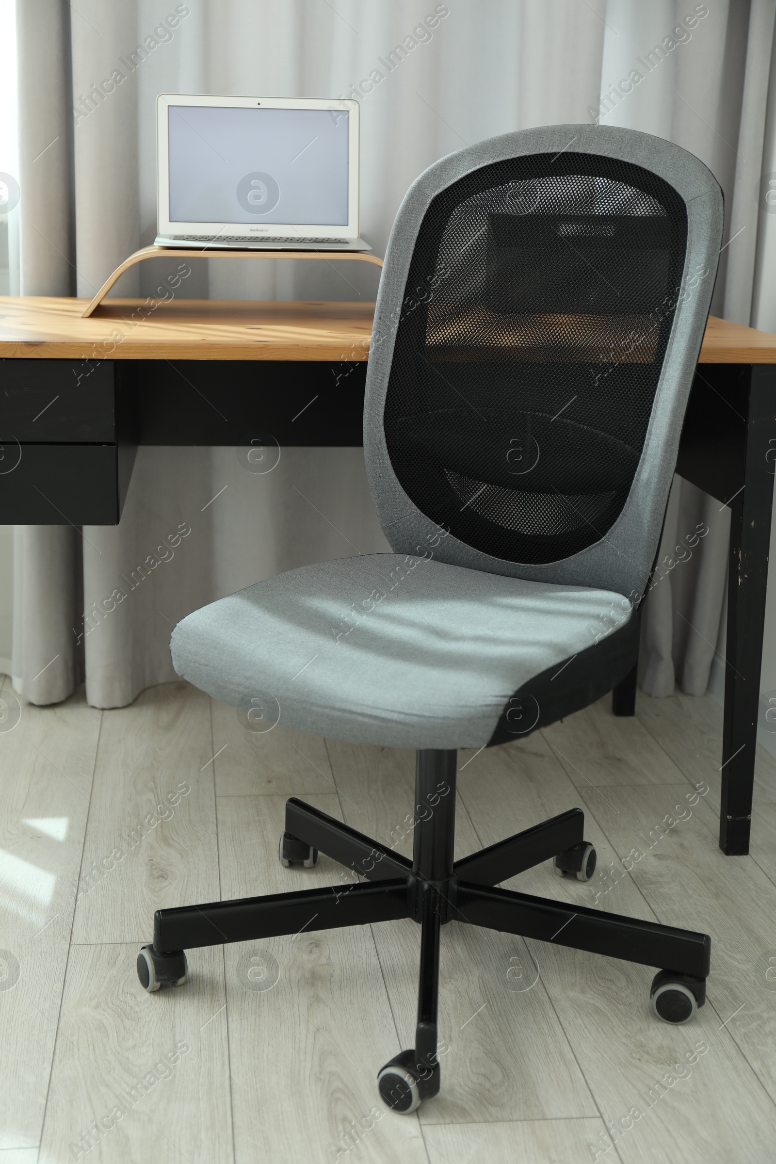 Photo of Grey chair, laptop and desk in office