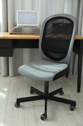 Grey chair, laptop and desk in office