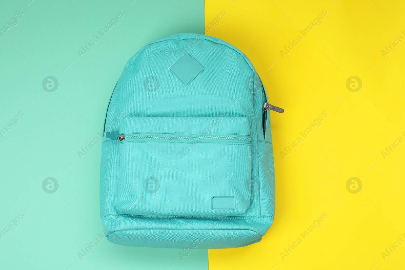 Photo of Turquoise school backpack on color background, top view