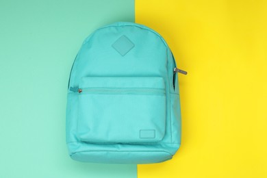 Turquoise school backpack on color background, top view