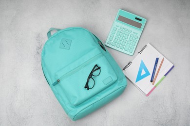 Photo of Flat lay composition with backpack and different school stationery on light grey table