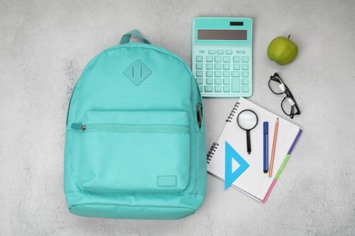 Photo of Flat lay composition with backpack and different school stationery on light grey table