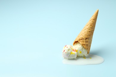 Photo of Melted ice cream in wafer cone on light background. Space for text