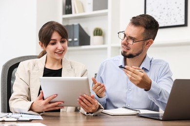 Photo of Consultant working with client at table in office. Business meeting