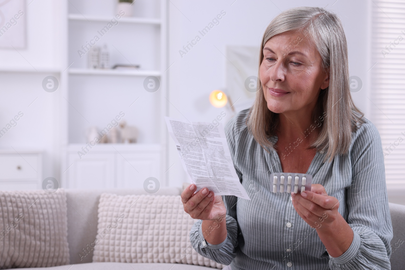 Photo of Senior woman with pills reading medicine instruction at home