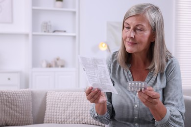 Senior woman with pills reading medicine instruction at home