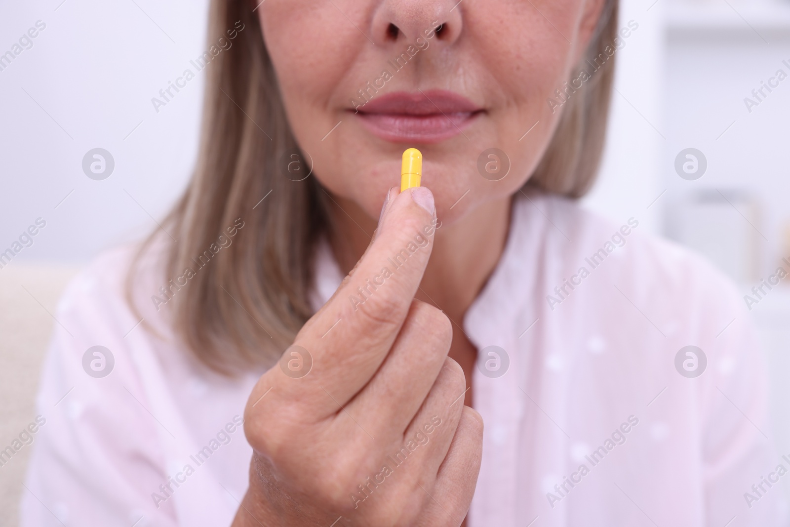 Photo of Senior woman taking pill at home, closeup