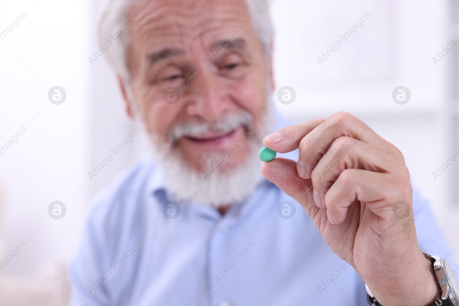 Photo of Senior man with pill at home, selective focus