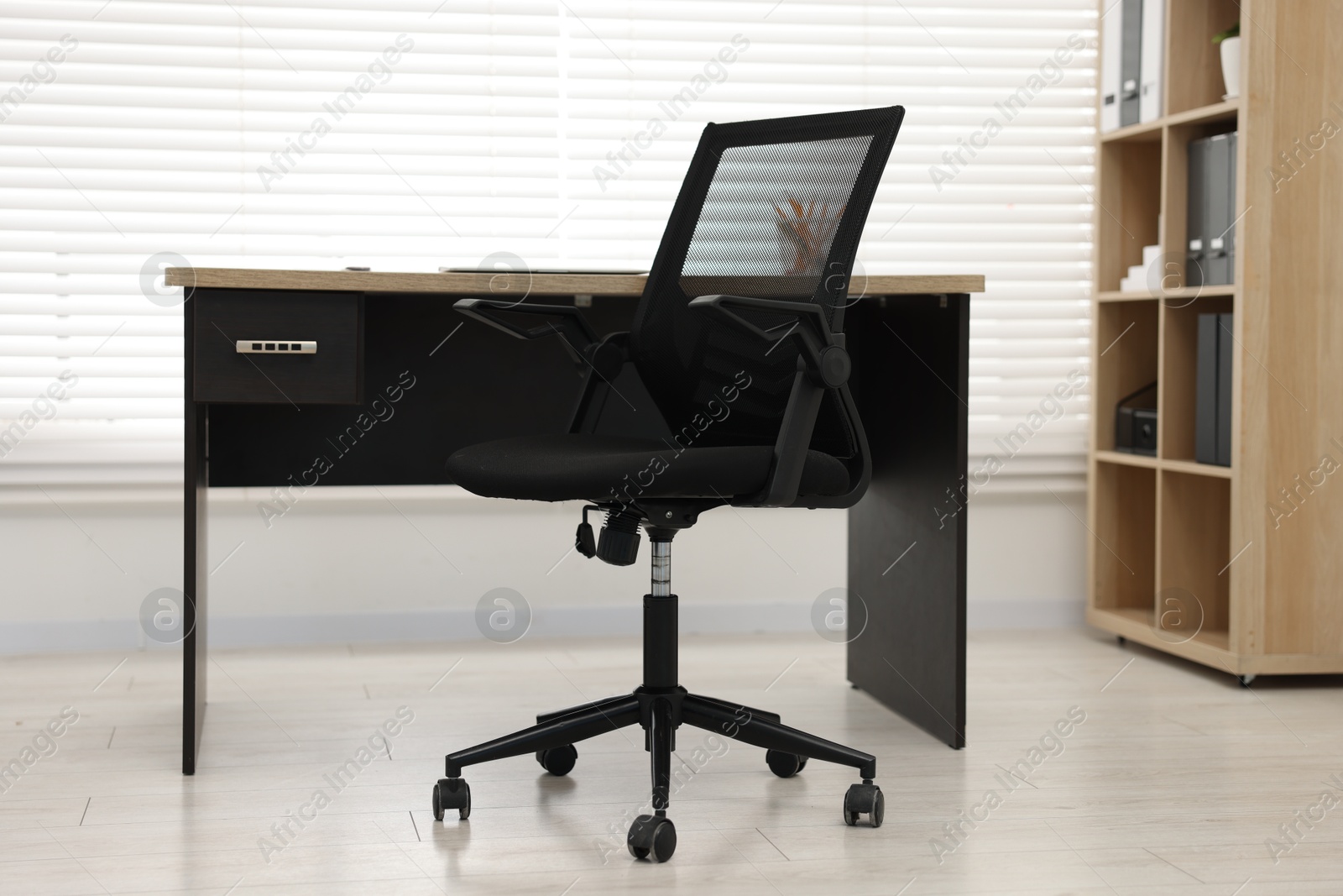 Photo of Black chair and wooden desk in office