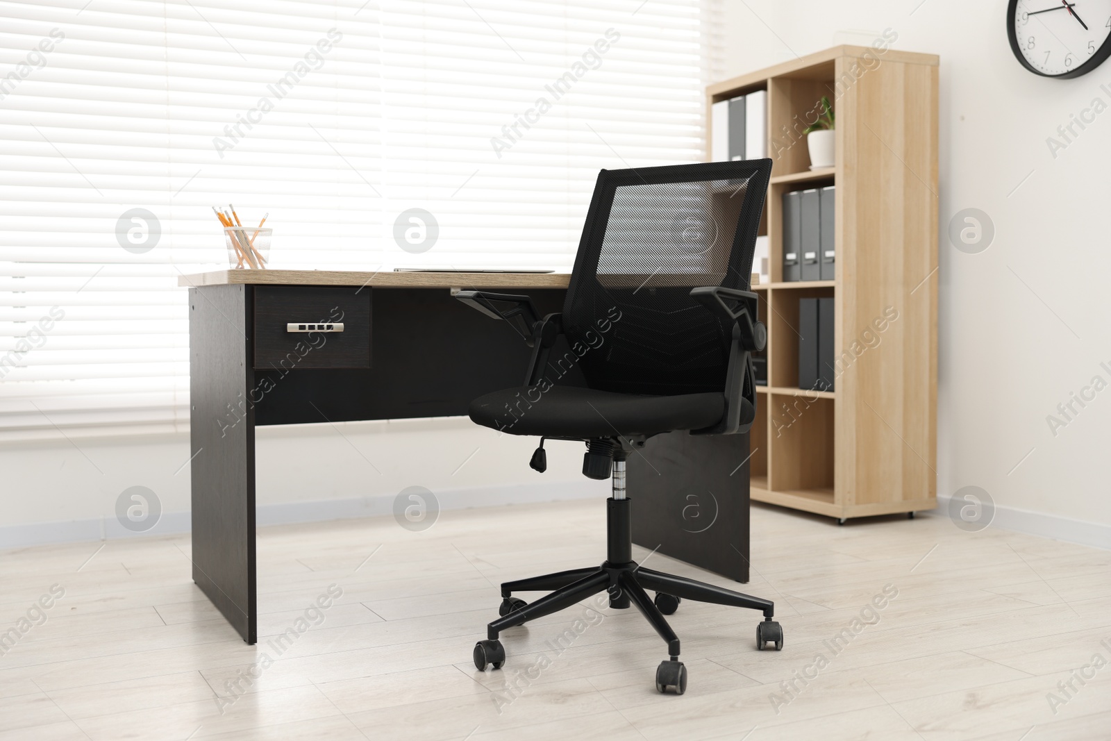 Photo of Black chair and wooden desk in office