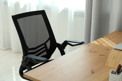 Black chair, laptop and desk in office