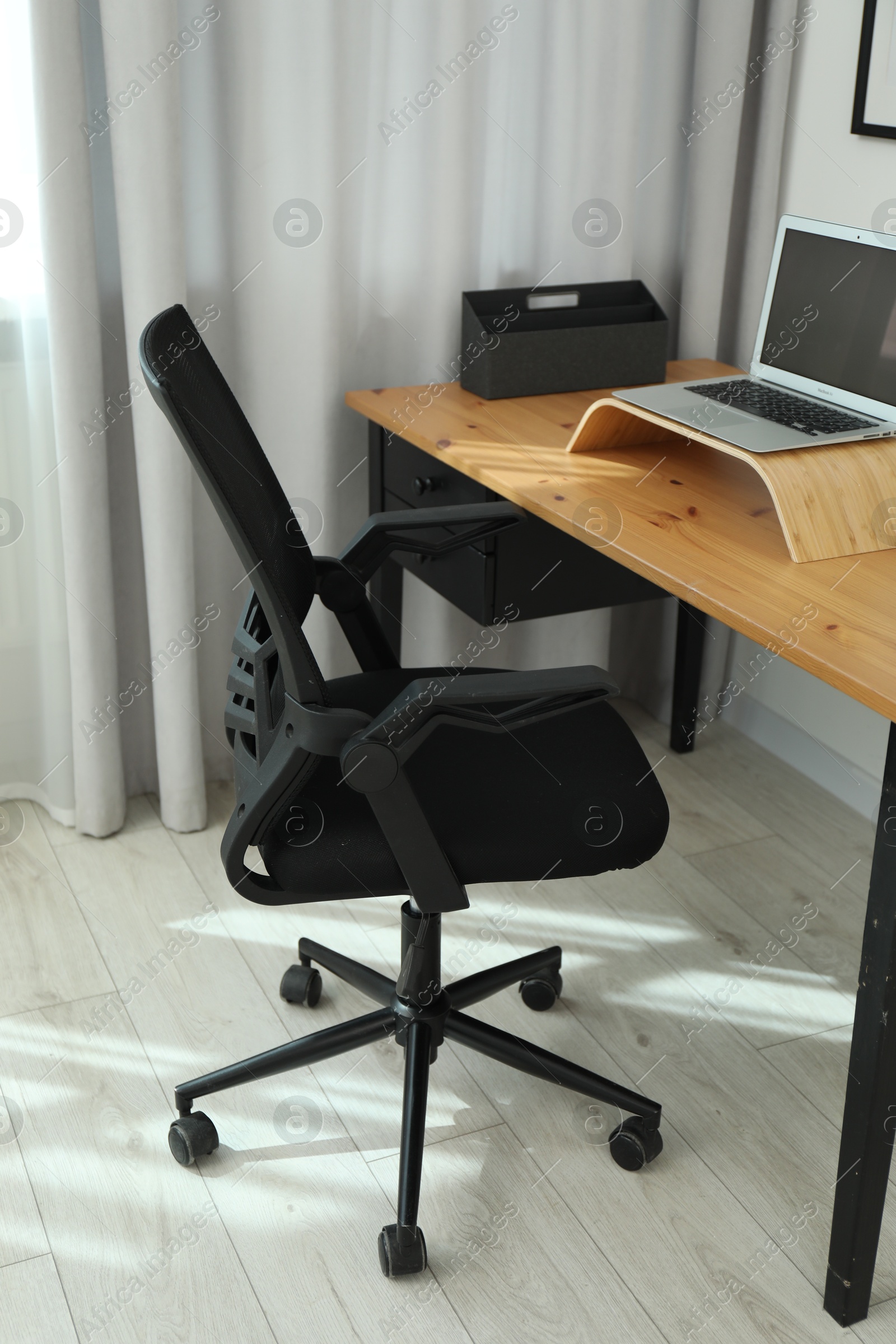 Photo of Black chair, laptop and desk in office