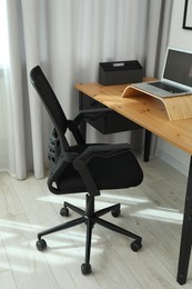 Photo of Black chair, laptop and desk in office