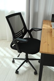 Black chair, laptop and desk in office