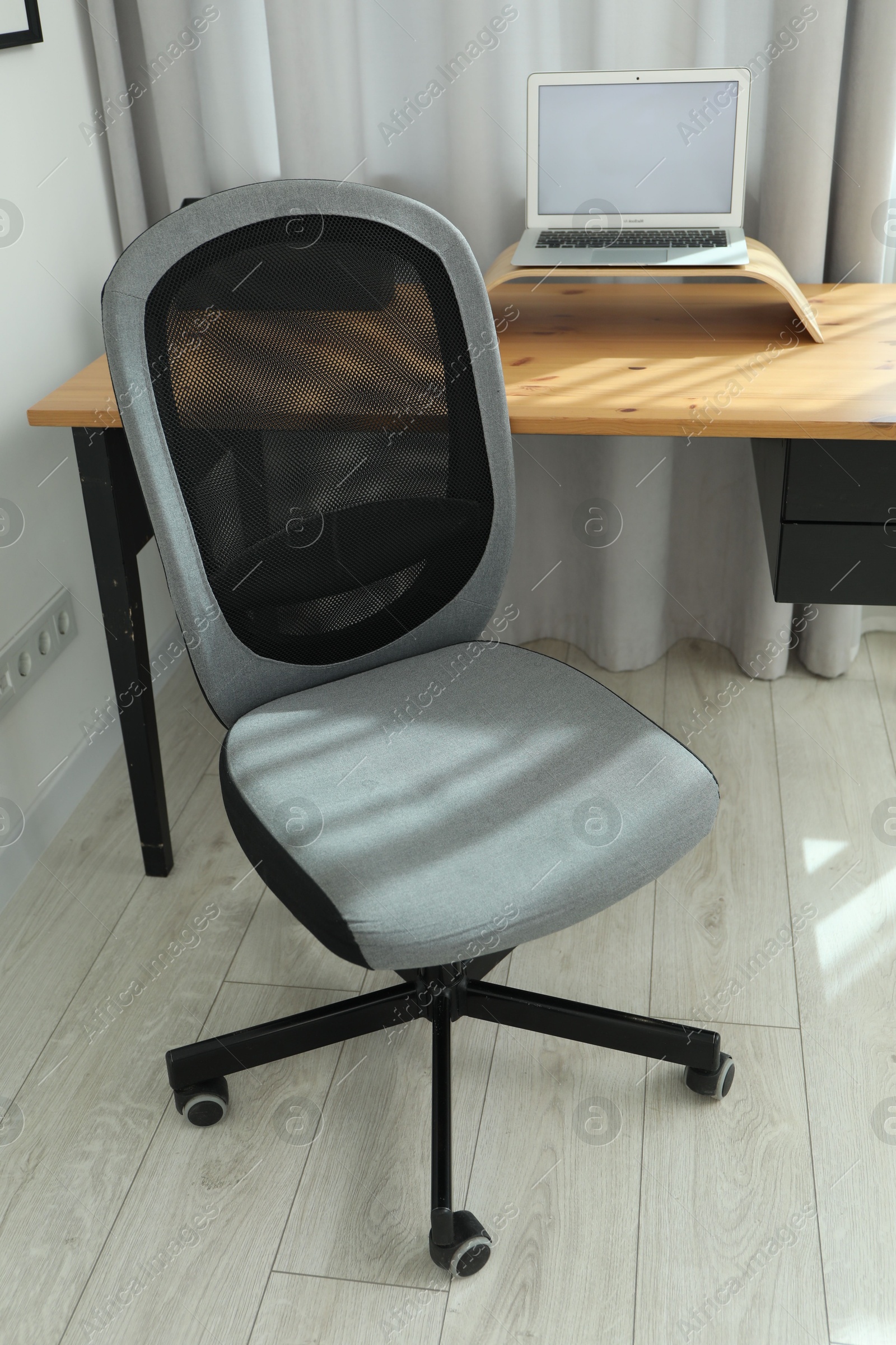 Photo of Black chair, laptop and desk in office