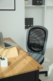 Grey chair, laptop and desk in office