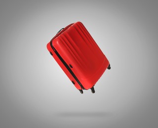 Image of Red suitcase in air on light grey background