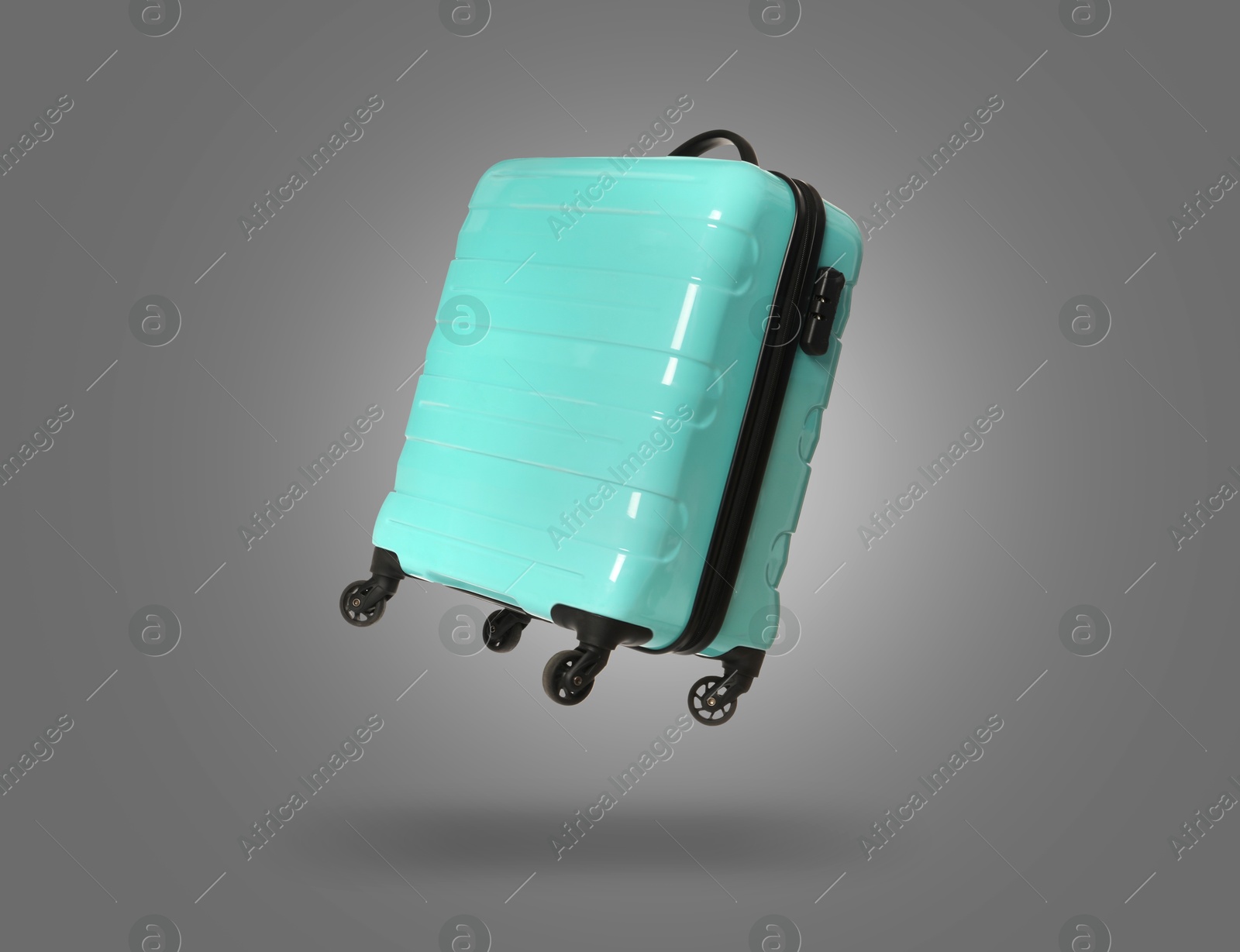 Image of Turquoise suitcase in air on grey background