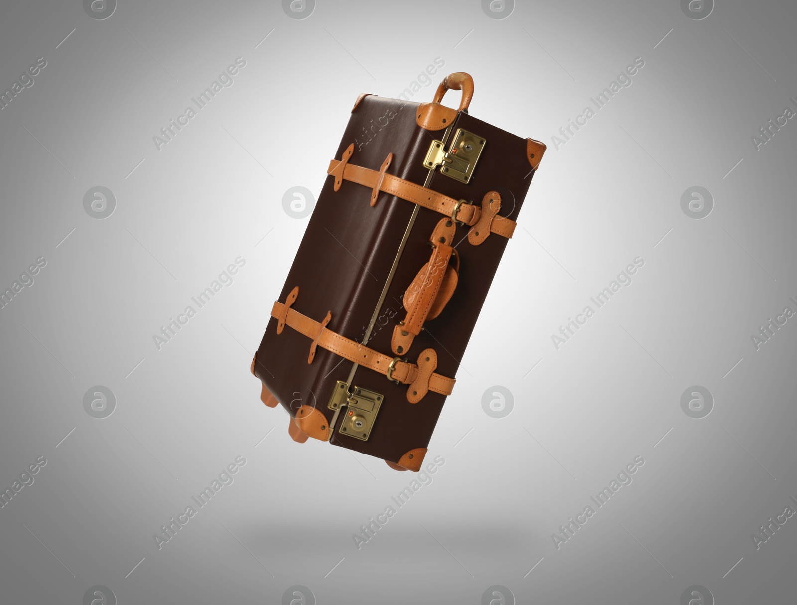 Image of Vintage suitcase in air on light grey background