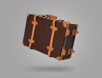 Image of Vintage suitcase in air on light grey background