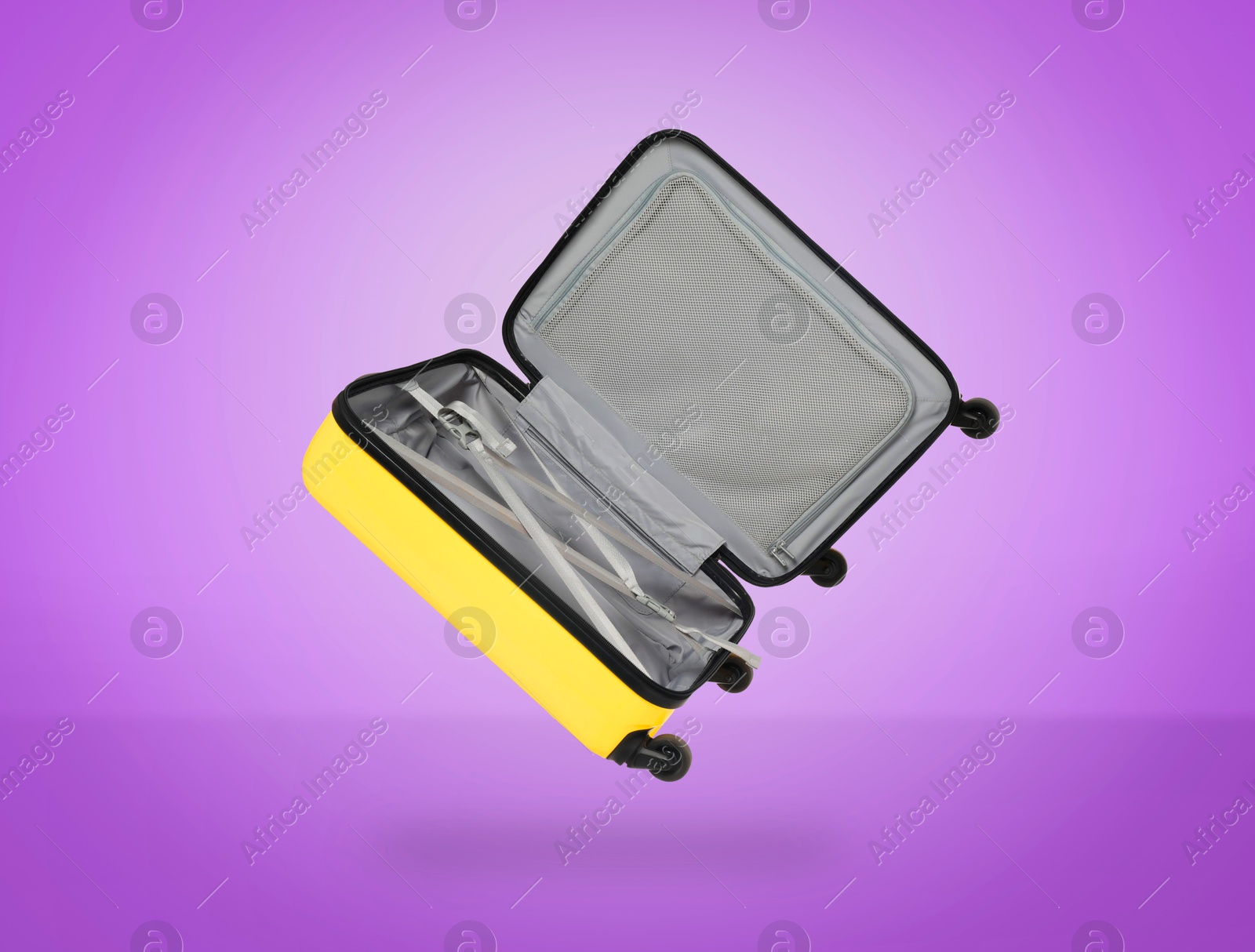 Image of Open empty suitcase in air on violet background