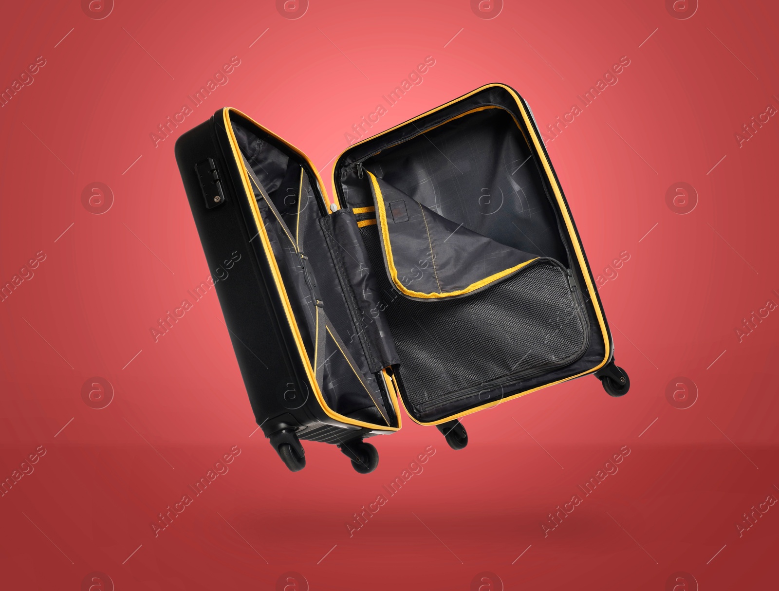 Image of Open empty suitcase in air on red background