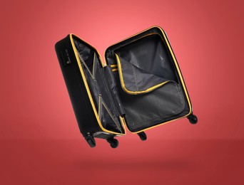 Image of Open empty suitcase in air on red background