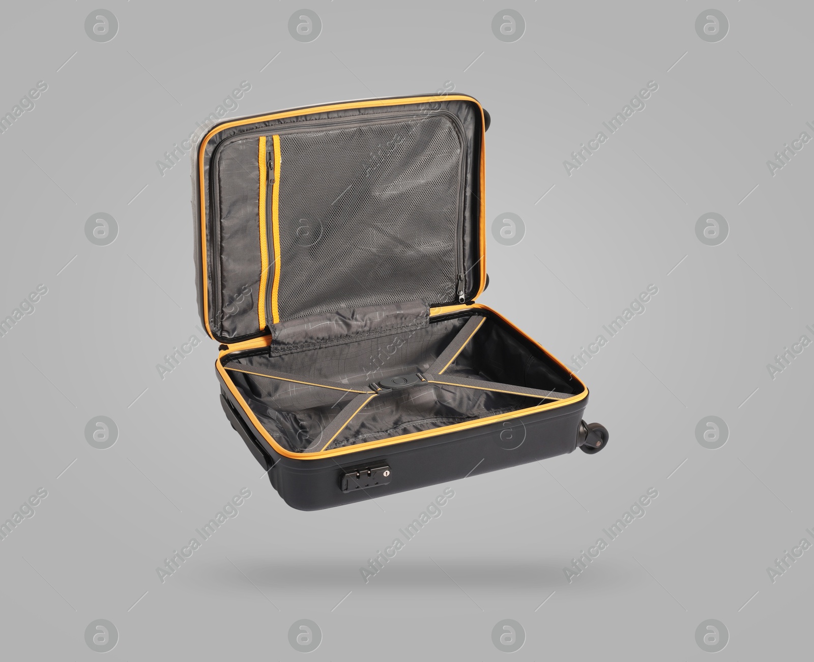 Image of Open empty suitcase in air on light grey background