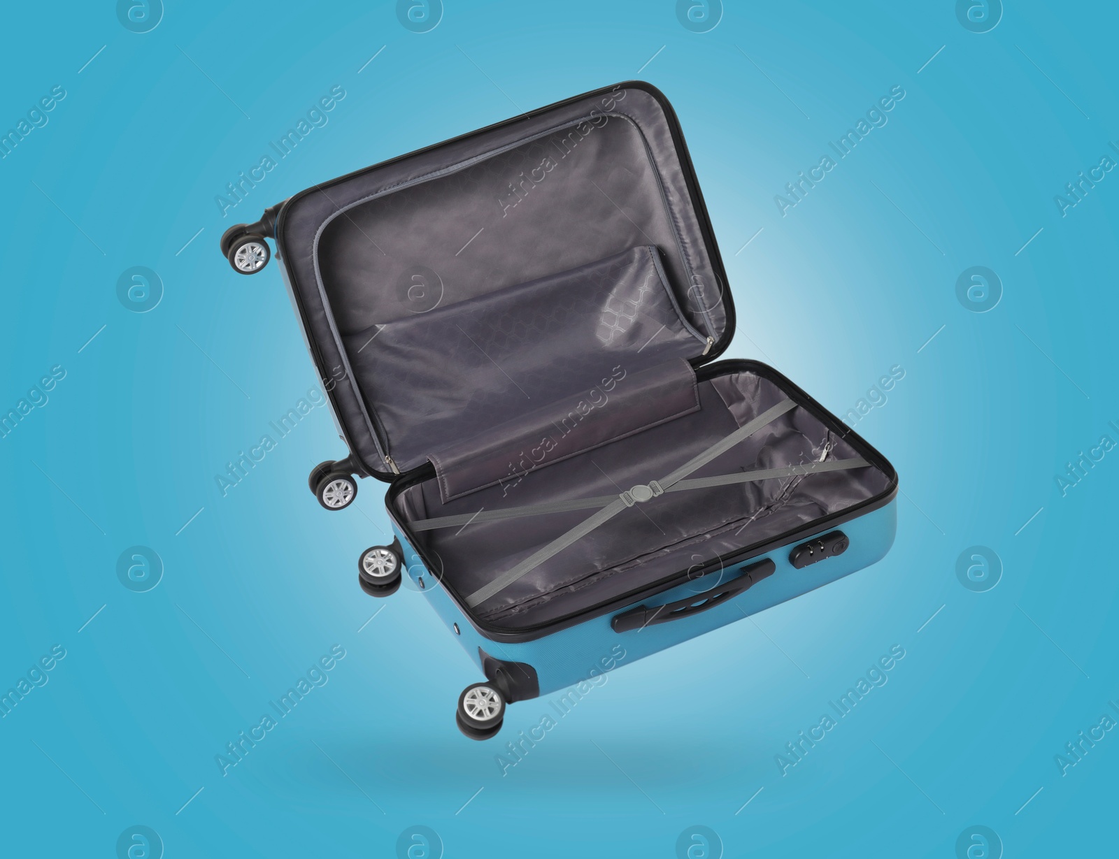 Image of Open empty suitcase in air on light blue background