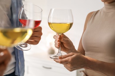 Photo of Friends with glasses of wine indoors, selective focus