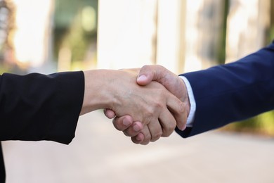 Photo of Diplomats shaking hands during meeting outdoors, closeup