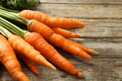 Tasty ripe juicy carrots on wooden table, closeup