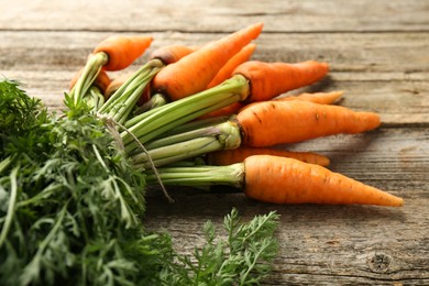 Tasty ripe juicy carrots on wooden table, closeup