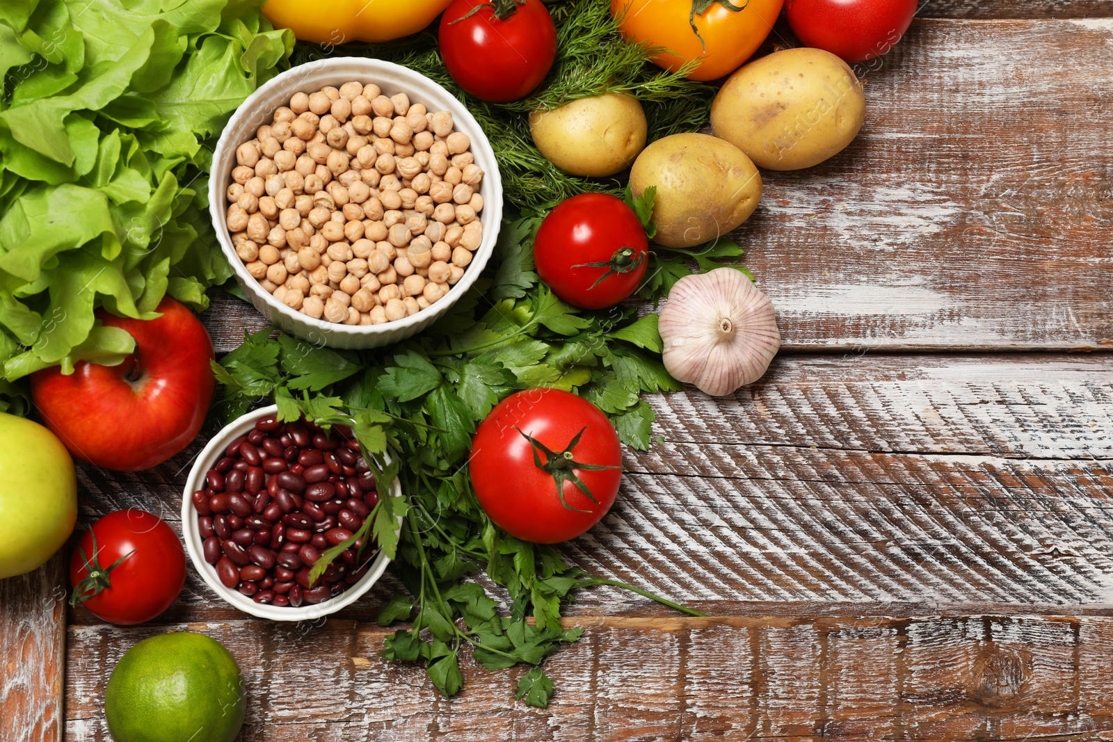 Photo of Different vegetarian products on wooden table, above view