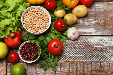 Photo of Different vegetarian products on wooden table, above view