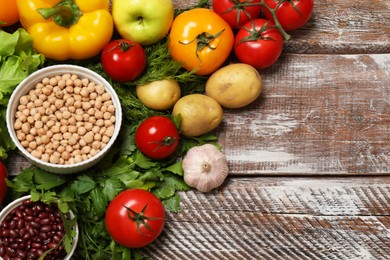 Photo of Different vegetarian products on wooden table, above view. Space for text