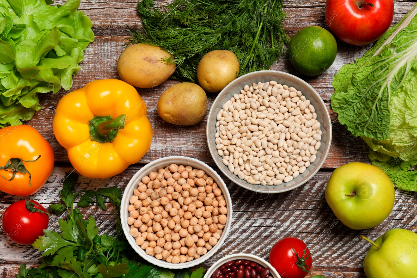 Photo of Different vegetarian products on wooden table, top view