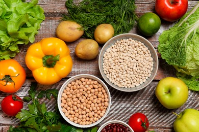 Photo of Different vegetarian products on wooden table, top view