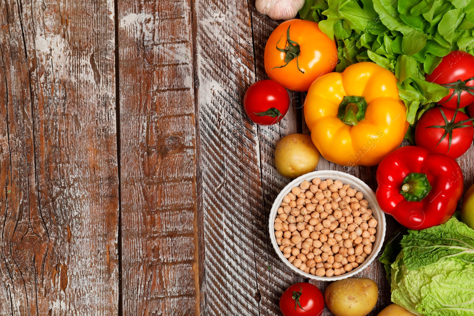 Photo of Different vegetarian products on wooden table, top view. Space for text