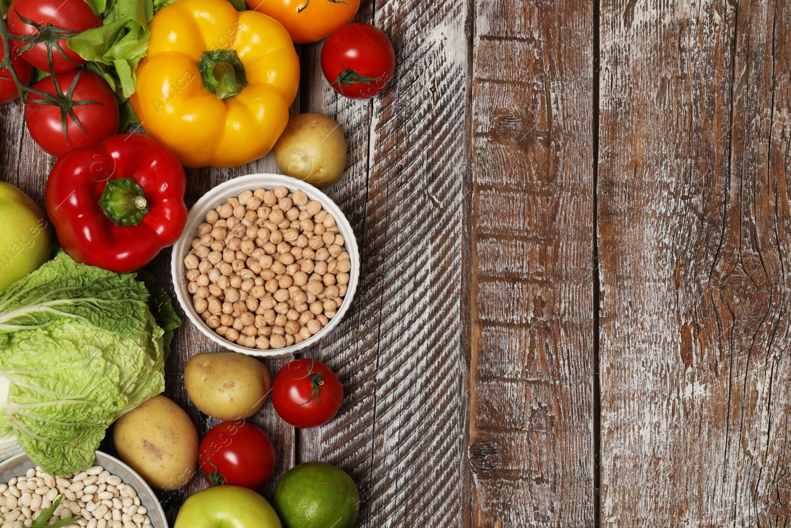 Photo of Different vegetarian products on wooden table, top view. Space for text