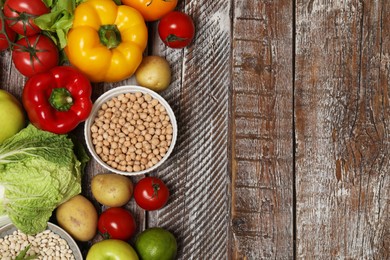 Photo of Different vegetarian products on wooden table, top view. Space for text