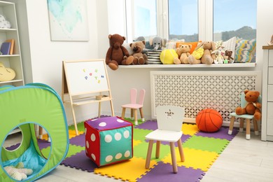 Stylish child room interior with different toys and furniture