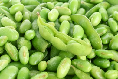 Photo of Raw green edamame soybeans and pods as background, closeup