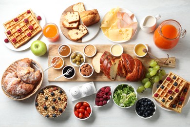 Photo of Different meals served for breakfast on white table, flat lay