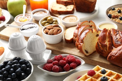 Different meals served for breakfast on white table