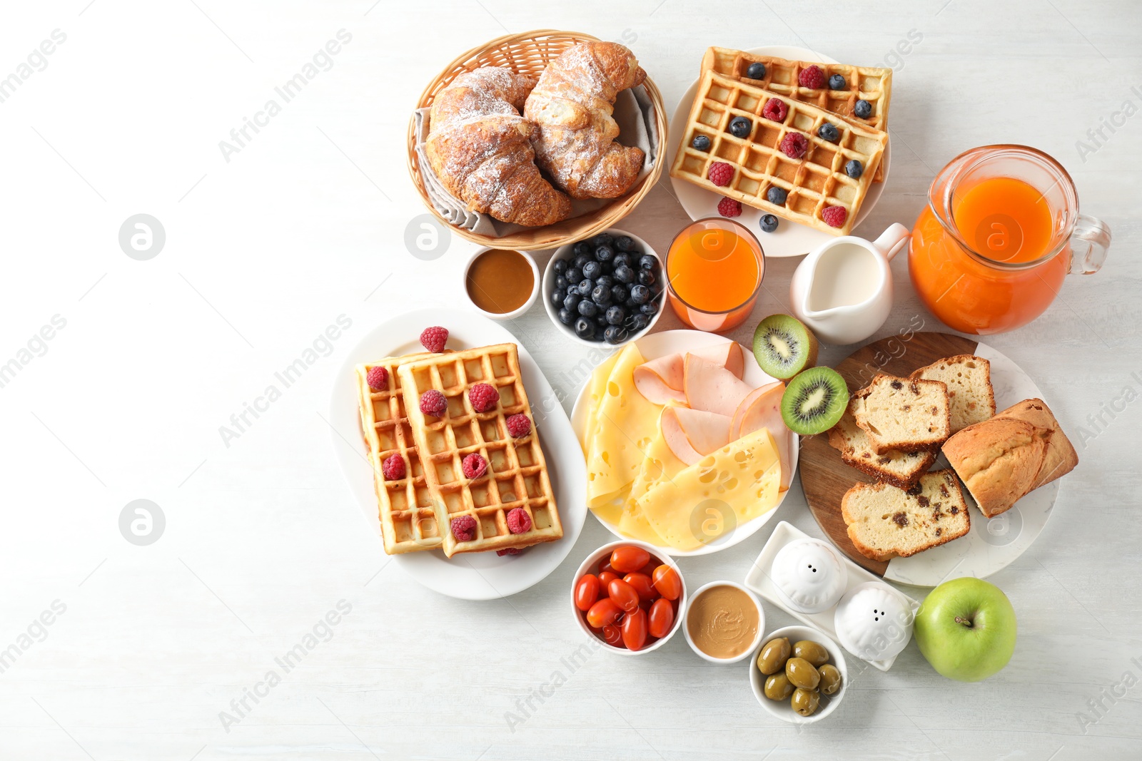 Photo of Different meals served for breakfast on white table, flat lay