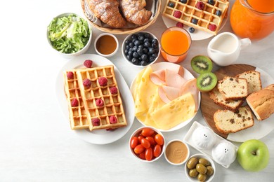 Photo of Different meals served for breakfast on white table, flat lay