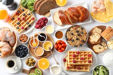 Photo of Different meals served for breakfast on white table, flat lay